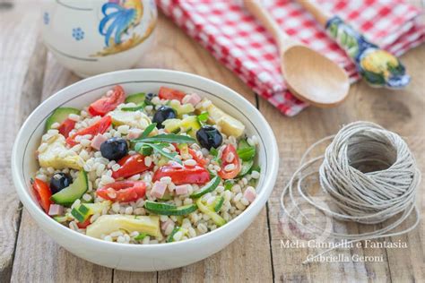 Ingredienti freschi per l'orzo alla contadina: orzo perlato, zucchine, pomodorini, olive, tonno, olio d'oliva.