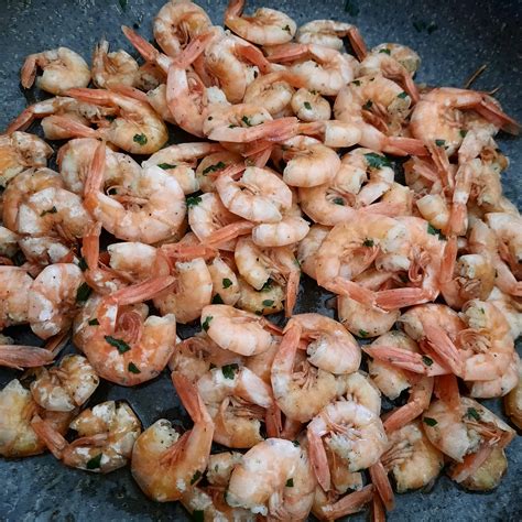 Gamberetti che sfrigolano in padella con aglio e prezzemolo