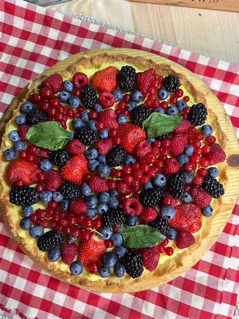 Illustrazione di una torta primaverile decorata con crema pasticciera e lamponi freschi