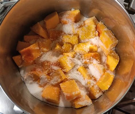 Zucca a cubetti in una pentola con zucchero, limone e spezie