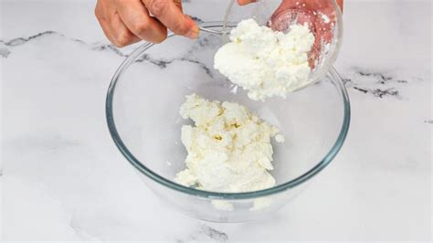 Immagine di una ciotola con soffice ricotta montata guarnita con frutta fresca e un filo di miele