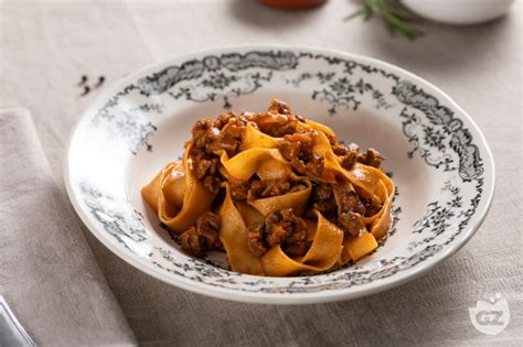 Piatto finito di tagliatelle al ragù d'anatra con guarnizione di scorza d'arancia.