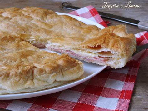 Fetta di torta salata con strati visibili di prosciutto, funghi e formaggio.