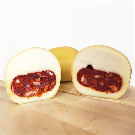 Composizione di pane calabrese con soppressata, formaggio e un bicchiere di olio EVO