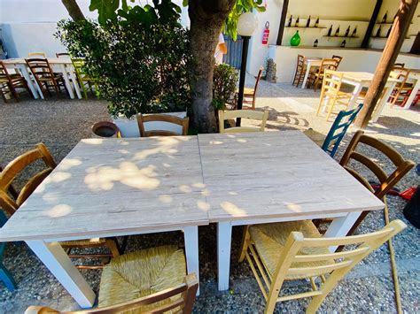 Arredamento esterno con tavoli e sedie colorate in un contesto di gelateria