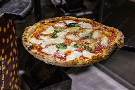 Primo piano di una pizza napoletana appena sfornata con abbondante condimento