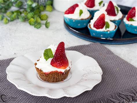 foto di cheesecake senza glutine monoporzione in pirottini, decorate con coulis di fragole e lamponi