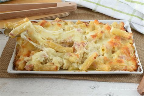 Primo piatto di pasta al forno con mozzarella filante e prosciutto cotto