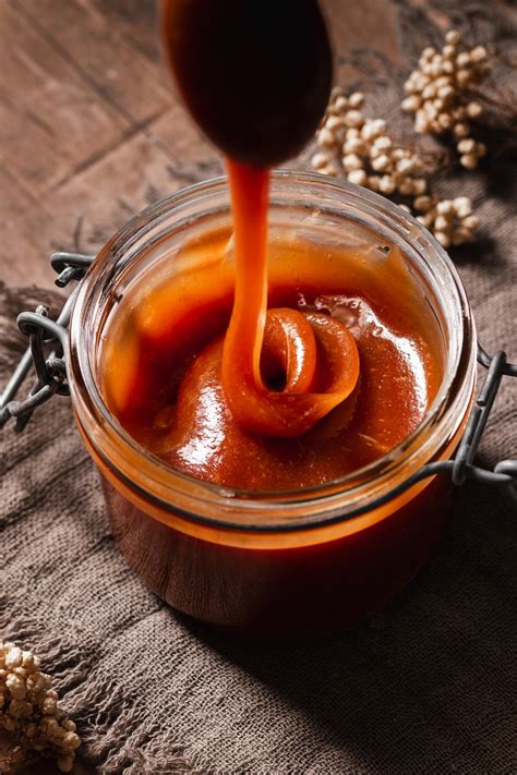 Preparazione della salsa al caramello vegan: sciogliere zucchero e acqua, aggiungere panna, margarina e sale.