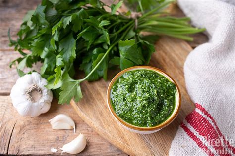 Ingredienti per la salsa verde vegana: prezzemolo fresco, frutta secca, aglio, olio, sale, pepe, aceto, capperi, cetriolino.