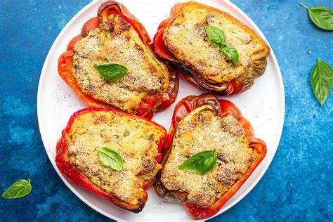 Peperoni ripieni colorati pronti per essere infornati, con il ripieno visibile.
