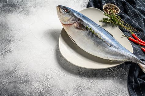 Ricciola intera cotta sotto crosta di sale, pronta per essere servita