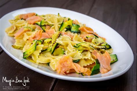 Piatto di pasta fredda estiva con salmone, pomodorini e zucchine.