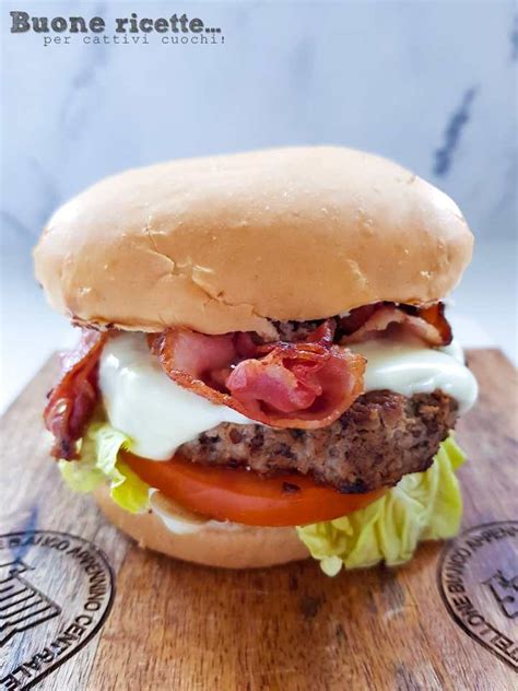 Padella con hamburger e bacon in cottura