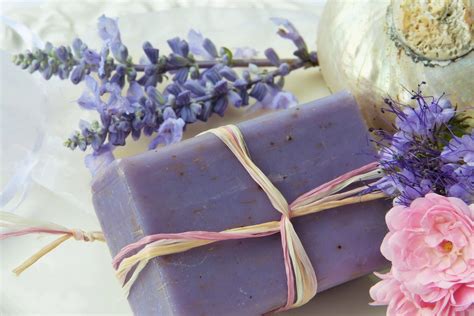 Dettaglio di un kit di benvenuto in camera con saponette artigianali e candela profumata