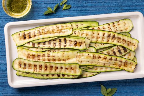 Piatto di zucchine grigliate condite con vinaigrette piccante e limone