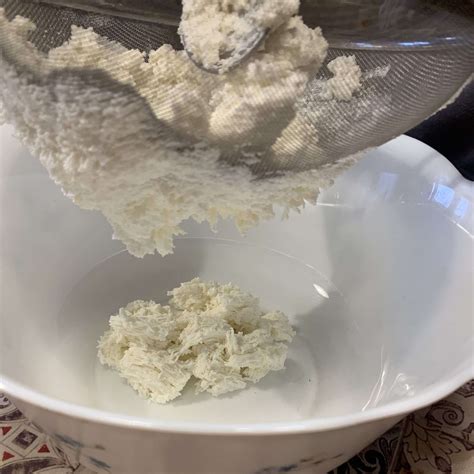 immagini di ricotta fresca in un colino per far scolare il siero