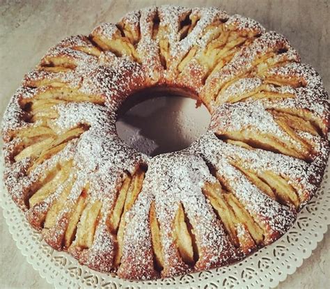 Una ciambella soffice con pezzi di pesca e amaretti visibili, posizionata su una gratella