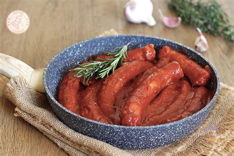 Immagine di salsiccia al sugo con un contorno di pane rustico