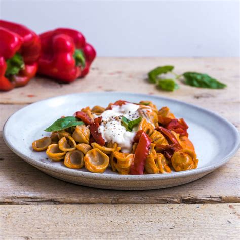 Immagine di un piatto di orecchiette colorate con peperoni e olive