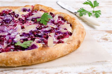 Immagine di una pizza con porri, radicchio e mozzarella filante, appena sfornata