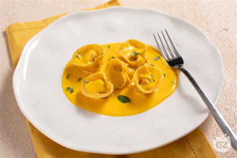 Immagine di tortelli di pesce persico serviti con salsa allo zafferano, guarniti con stigmi di zafferano.
