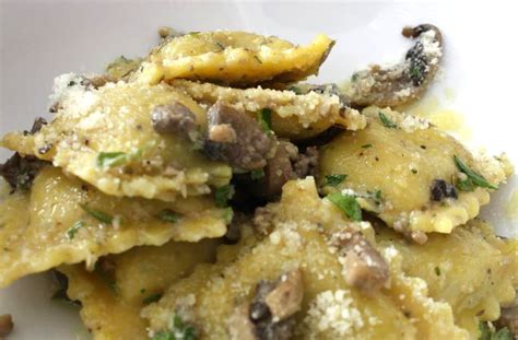 Immagine di ravioli di baccalà serviti con una salsa ai funghi.