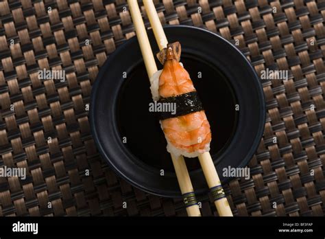 Una ciotola di sushi misto su un tavolo di legno con bacchette