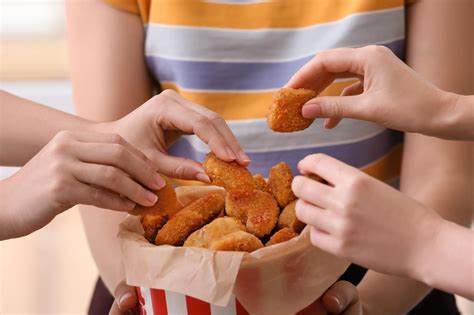 Bambino che aiuta a formare i nuggets di pollo
