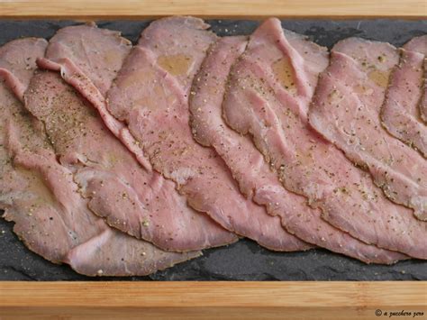Una tavola apparecchiata con un roast beef affettato, contorni e salse, pronto per essere gustato.