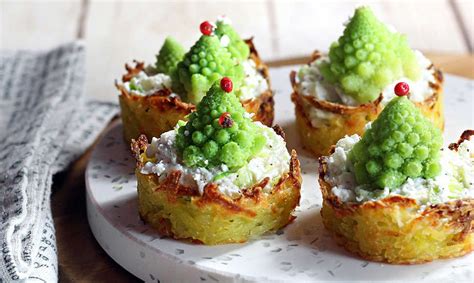 Alberelli di cavolo romanesco infilzati su basi di pane e formaggio, decorati con parmigiano e pepe rosa.