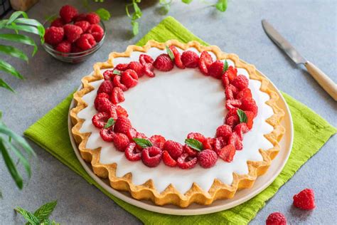 Immagine di una crostata decorata con lamponi e menta