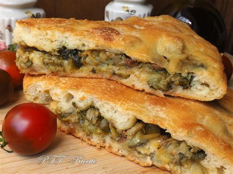 Immagine di una focaccia ripiena dorata e fragrante, tagliata a fette per mostrare il ripieno ricco di baccalà, patate e cavolfiore.