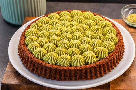 Immagine di una crostata con la crema al pistacchio già versata e le strisce di frolla pronte per essere disposte