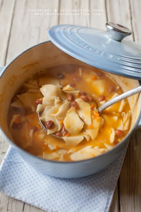 Immagine di una ciotola fumante di zuppa maltagliati e fagioli con pancetta e erbe aromatiche
