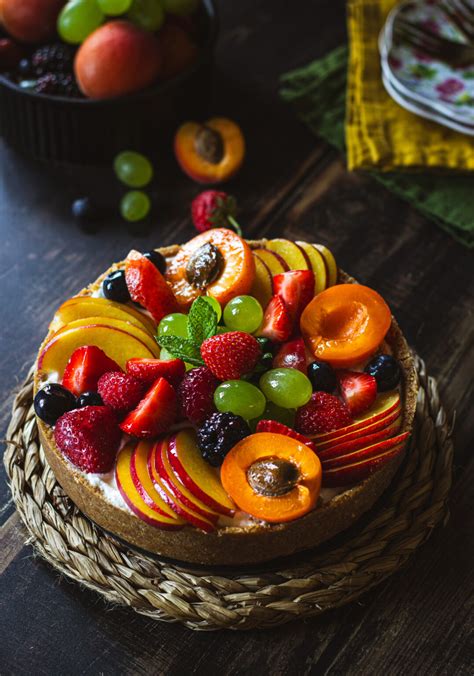 una cheesecake senza cottura completamente decorata con marmellata di lamponi e frutta fresca
