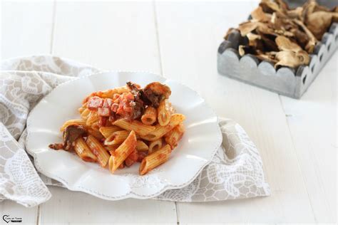Ingredienti freschi per la pasta con funghi e ricotta, con porcini, ricotta, noci e pomodori secchi in primo piano.