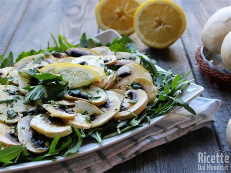 Composizione di ingredienti per la pasta: funghi champignon freschi affettati, ricotta in una ciotola, gherigli di noci, pomodori secchi e aromi come prezzemolo e aglio.