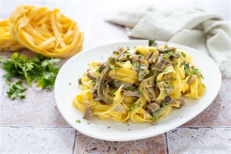 Immagine di un piatto invitante di tagliatelle con funghi e zucchine, guarnito con prezzemolo fresco.