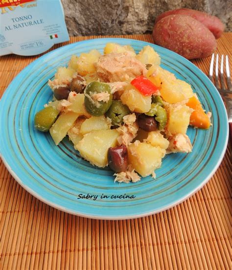Terrina con patate, tonno e olive condite, pronte per riposare in frigorifero