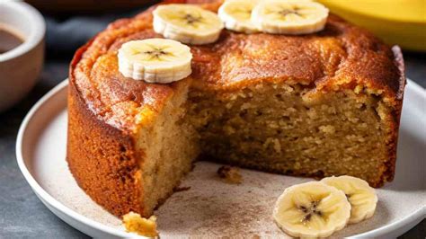 fetta di torta di avena e banana su un piatto, con accanto una ciotola di yogurt e frutti rossi
