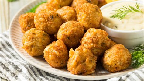 Un piatto di polpette di merluzzo fritte, croccanti fuori e morbide dentro, servite con una salsa.