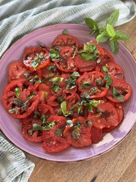varietà di pomodori maturi e basilico fresco disposti su un tagliere