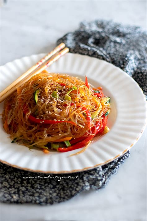 Immagine di spaghetti di soia cotti con verdure colorate e guarniti con semi di sesamo