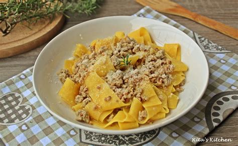 Immagine di un piatto di pappardelle al ragù bianco e porcini, con guarnizione di prezzemolo fresco.