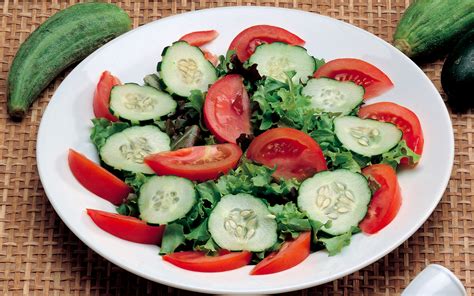 Insalata mista con pomodori, cetrioli e olive, su uno sfondo bianco luminoso, con una luce solare che la illumina, a rappresentare la freschezza e la leggerezza del sorriso.