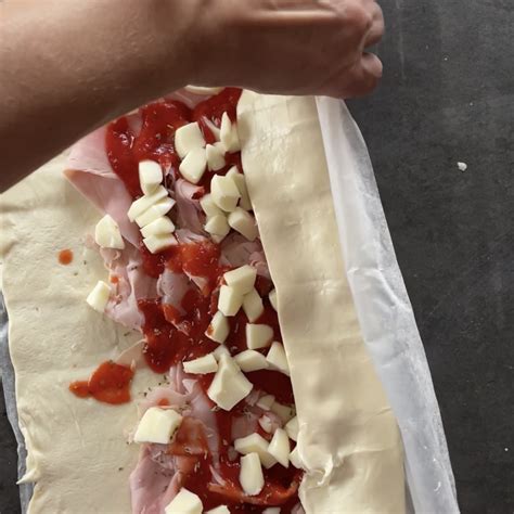 pizza senza latticini arrotolata a forma di rosa, pronta per essere infornata