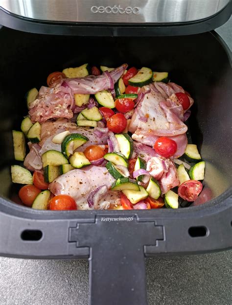 Coniglio e verdure disposti nel cestello della friggitrice ad aria prima della cottura