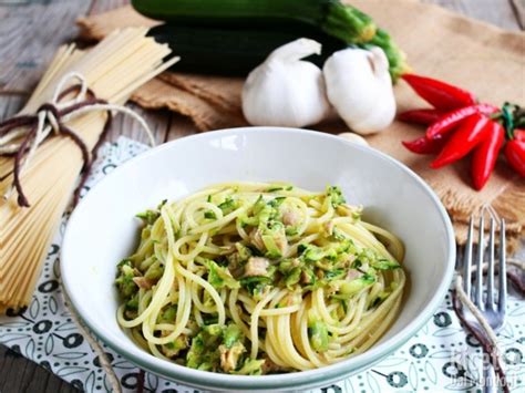 Una ciotola con spaghetti di zucchine, tonno, olive e noci, pronta per essere mangiata con le bacchette