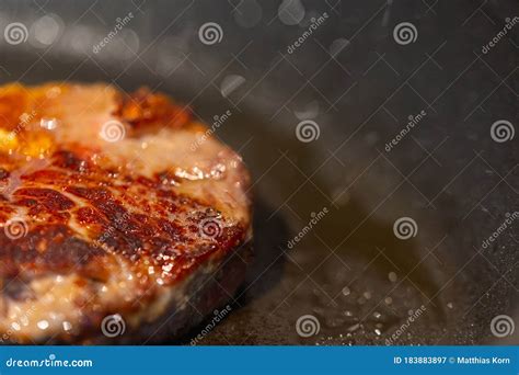 Immagine di una padella in ghisa che cuoce una bistecca, con un'aura di calore che si diffonde uniformemente.